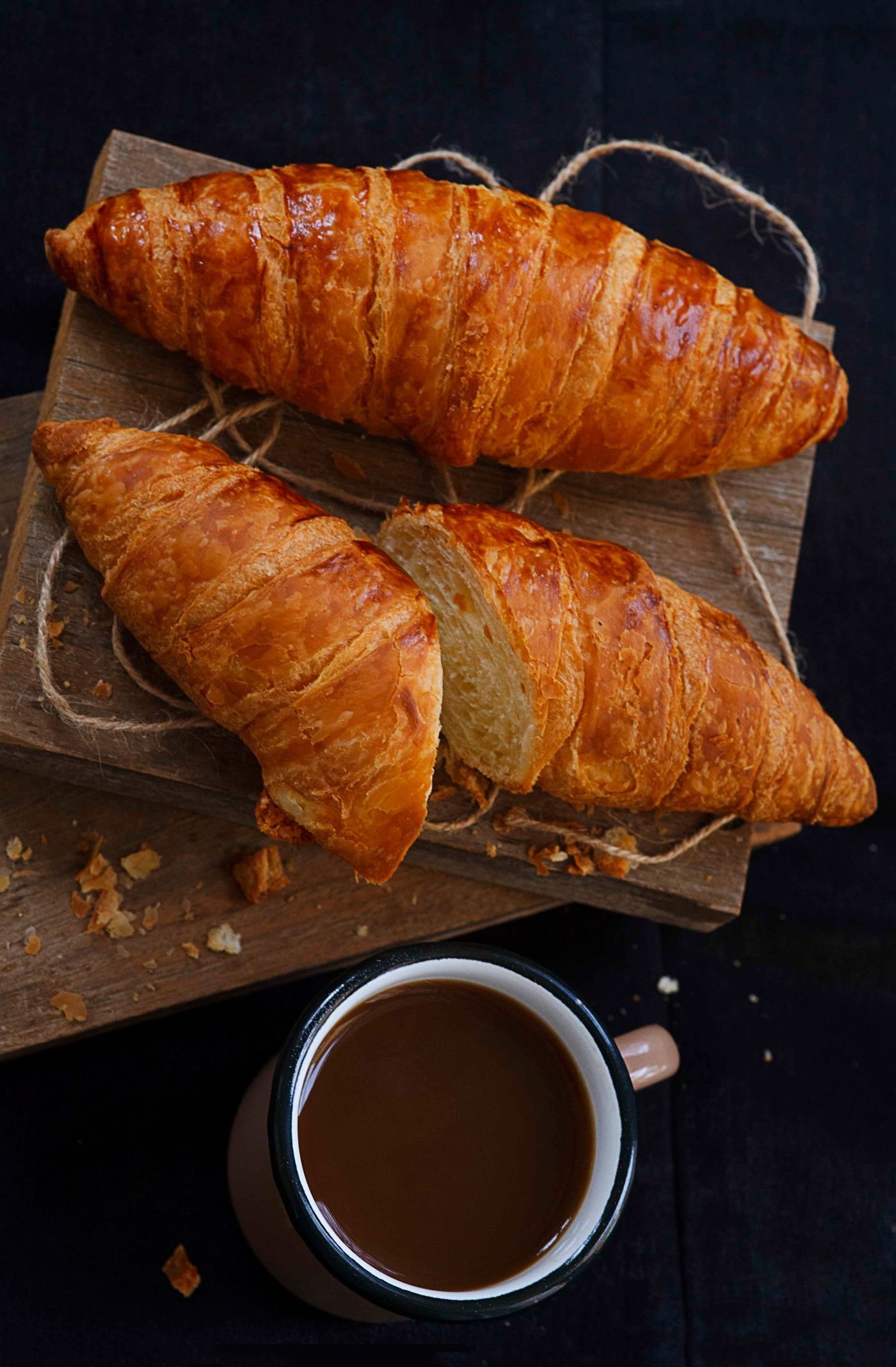 Two golden croissants with coffee